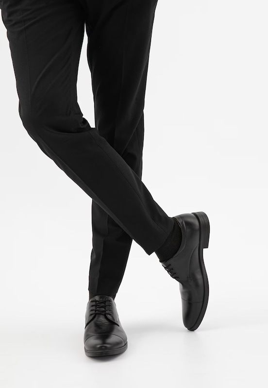 Detail modela v elegantních kožených botách