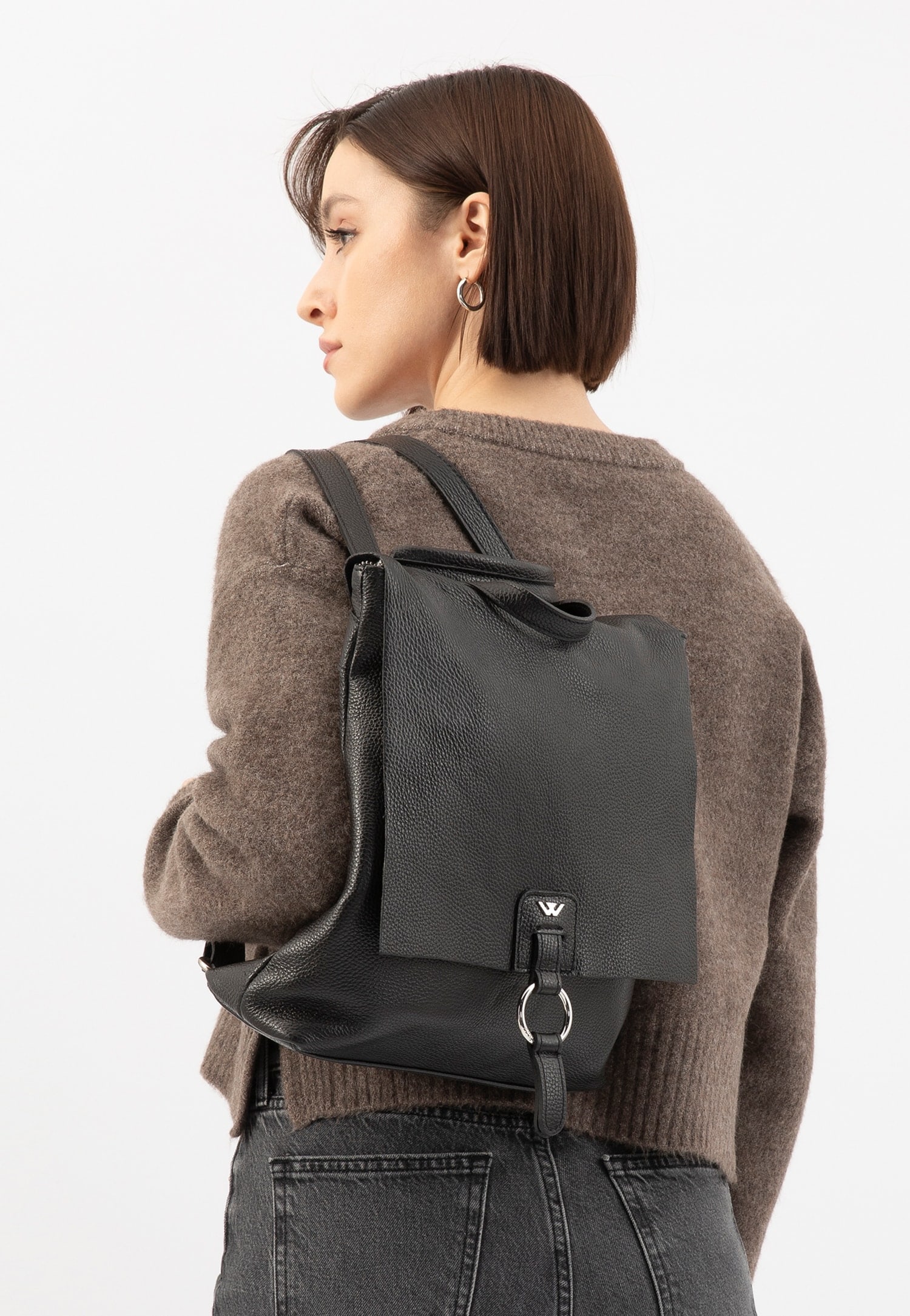 kabelko-batoh a modelka v hnědém svetru a tmavých džínách