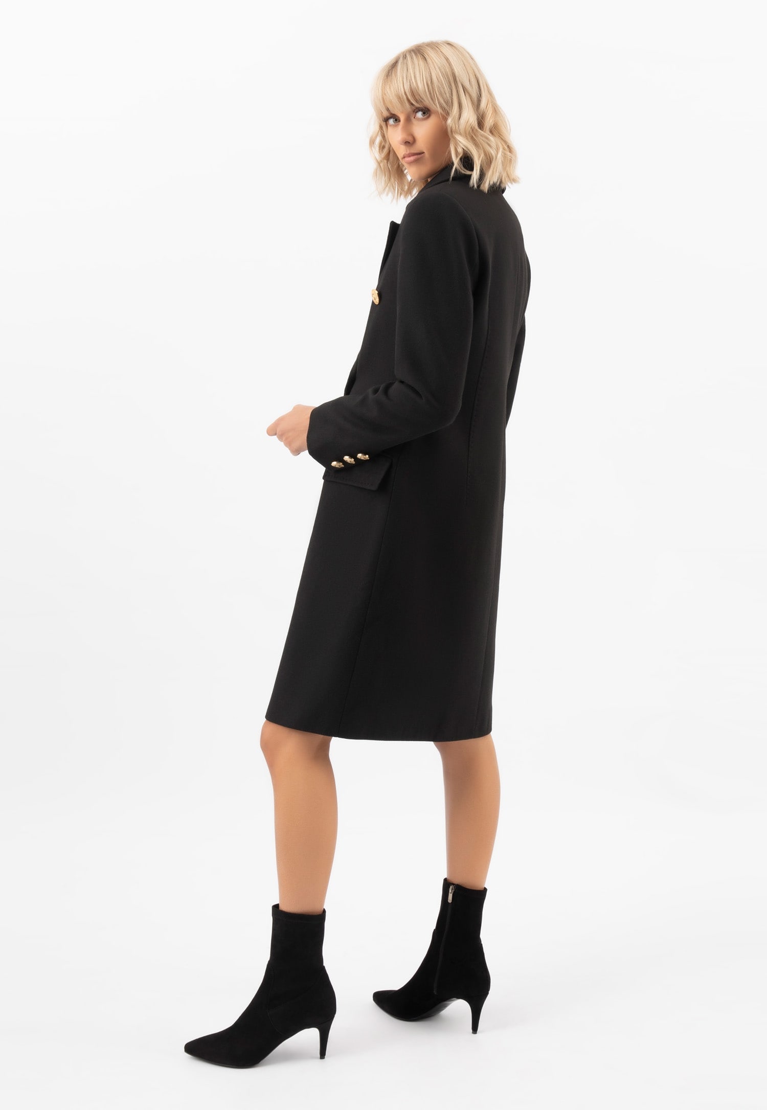 černé kotníkové boty s ponožkovým svrškem a modelka v černém kabátě