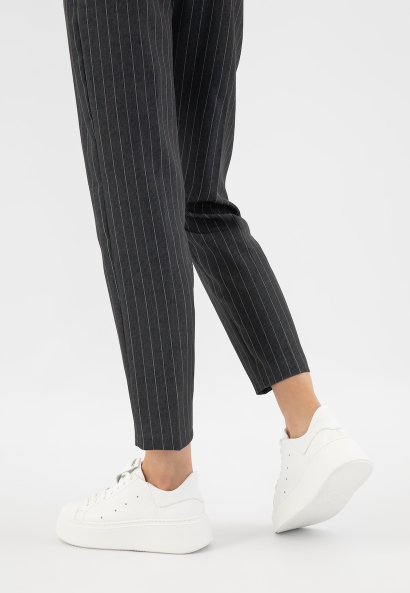 białe sneakersy w połączeniu z eleganckimi, szarymi spodniami