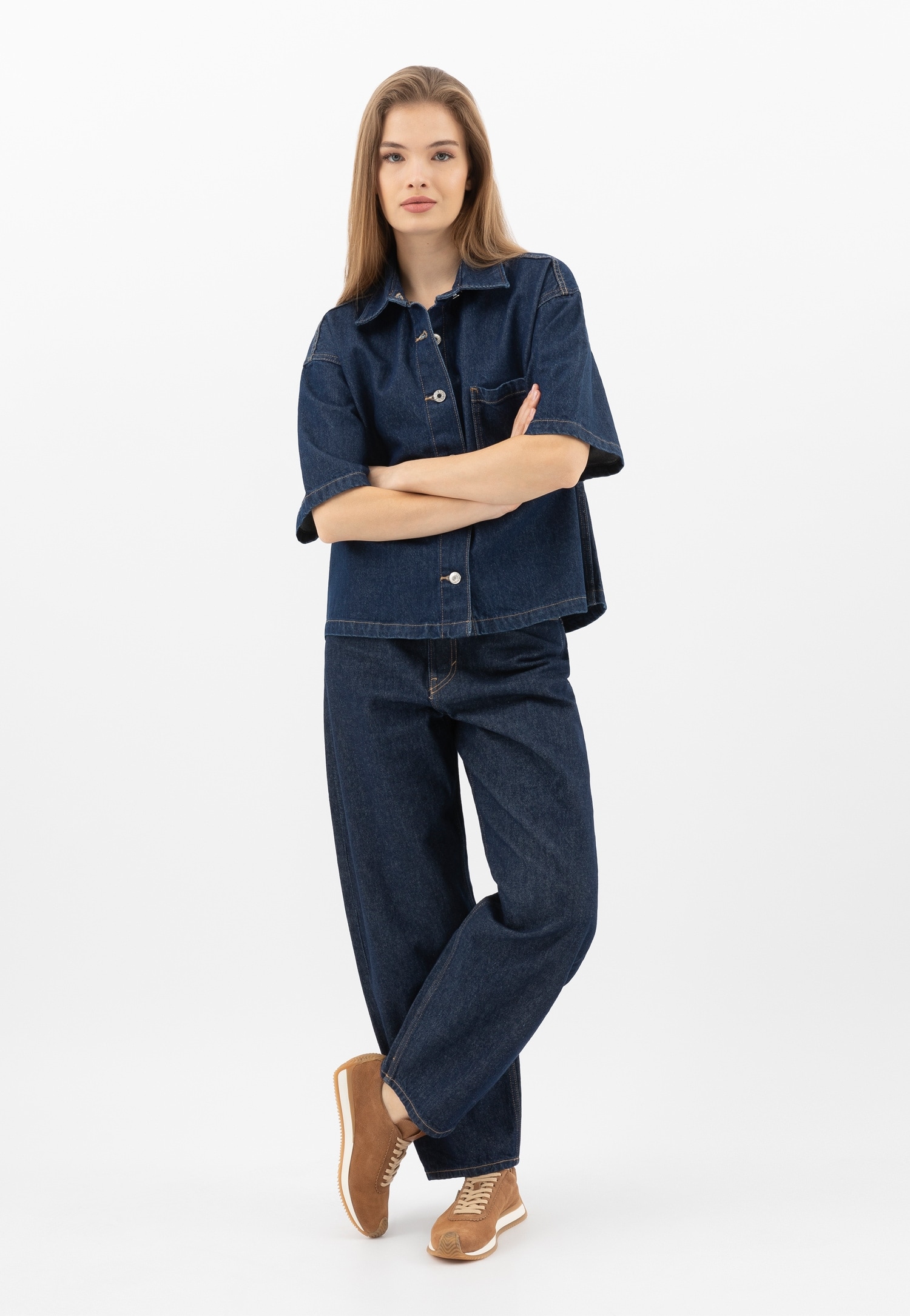 Brązowe sneakersy i modelka w jeansowym komplecie