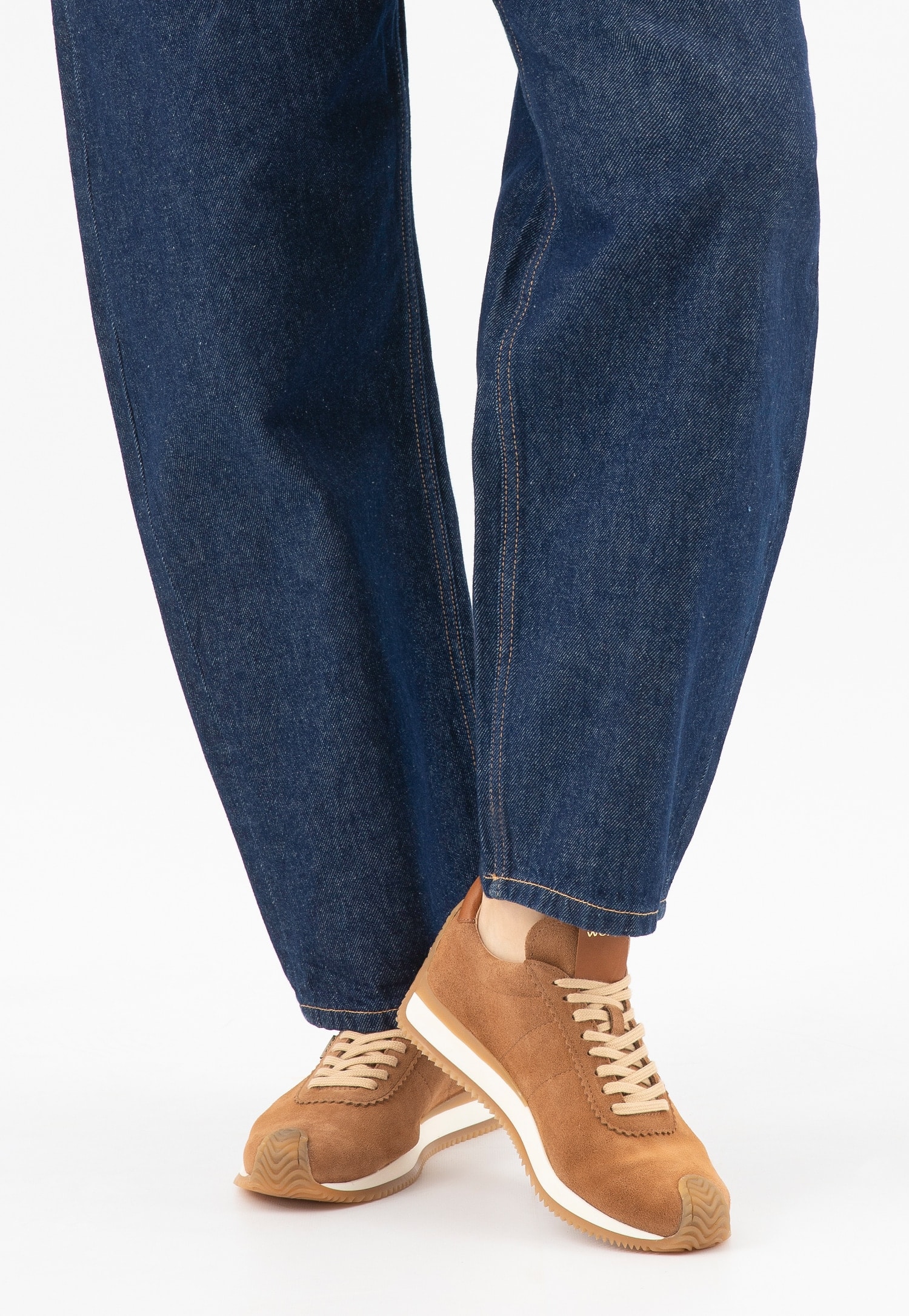 Zamszowe sneakersy modelka w ciemnych jeansach