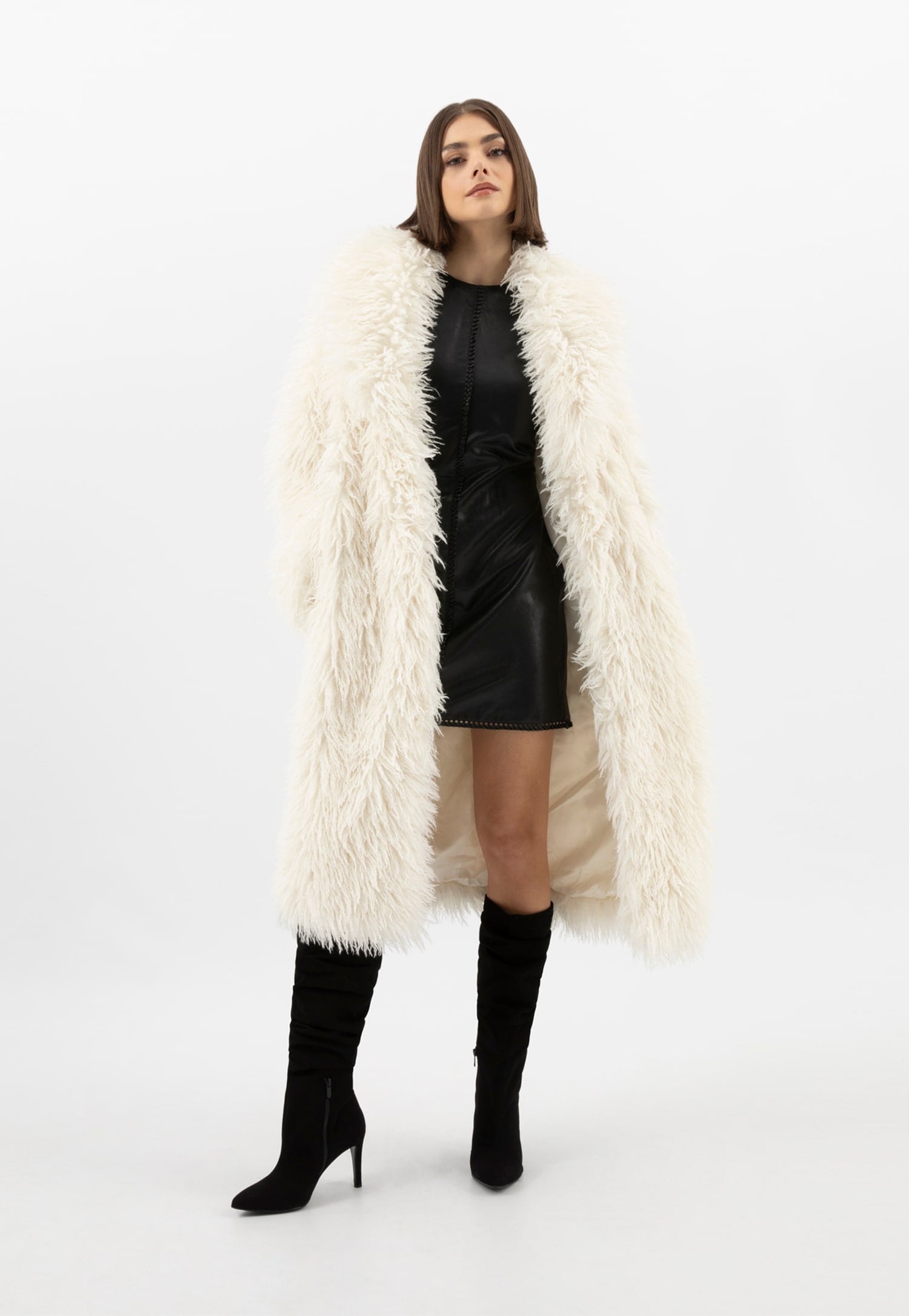 Modelka w czarnej sukience i czarnych botkach i białym futerku