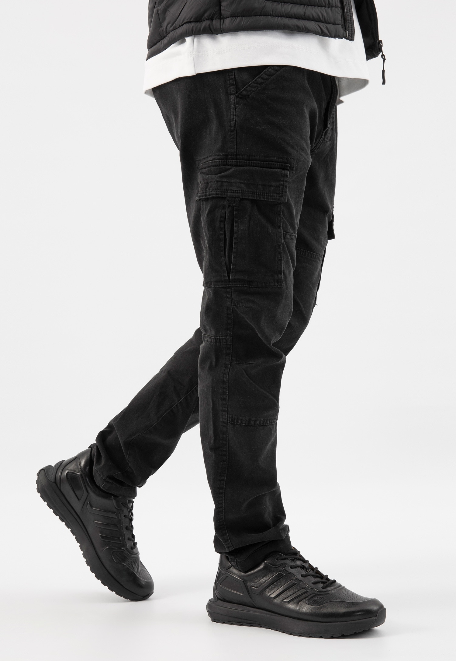 Czarne sneakersy męskie i ciemne jeansy typu cargo