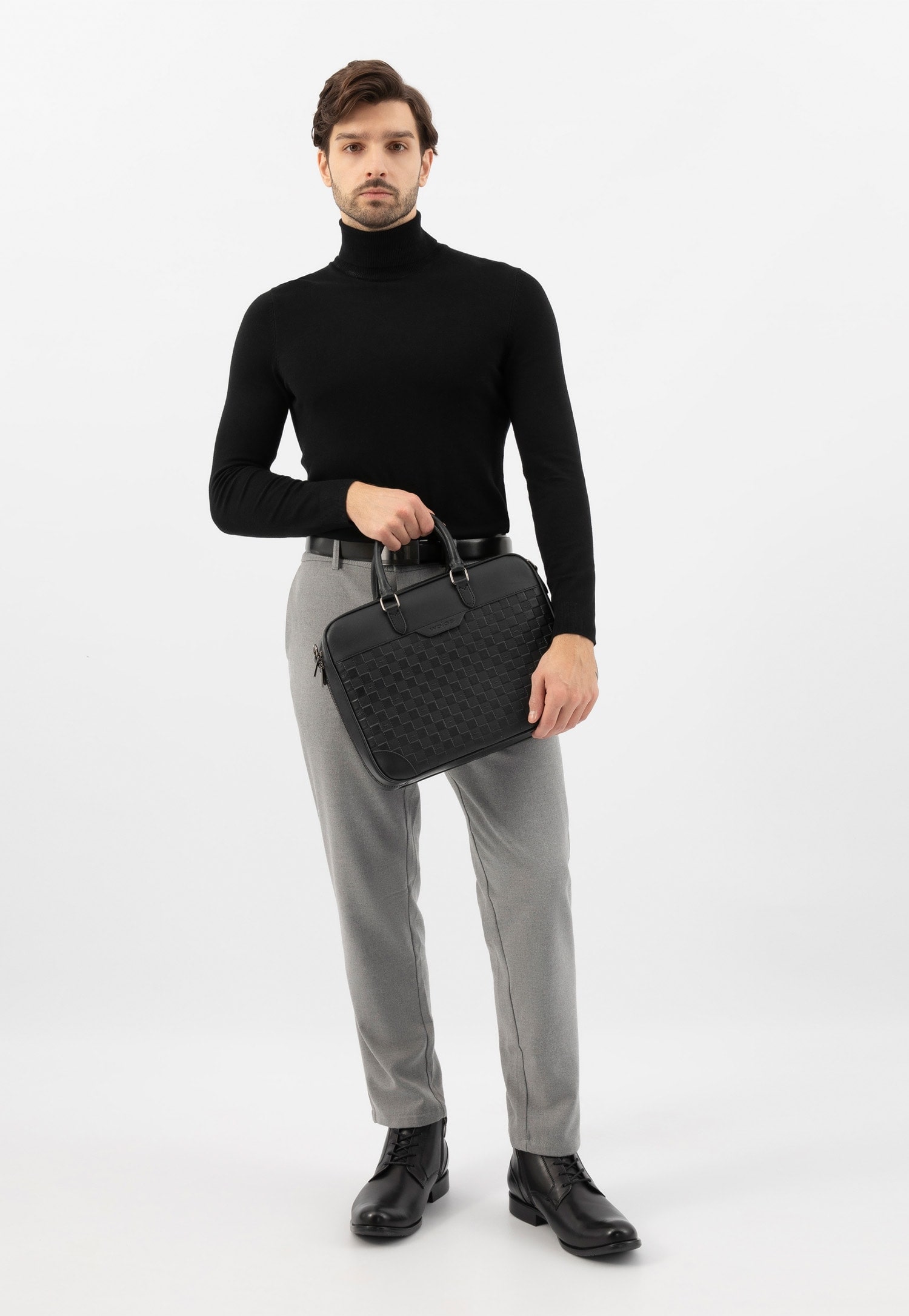 Czarna skórzana torba na laptopa i model w szarych spodniach