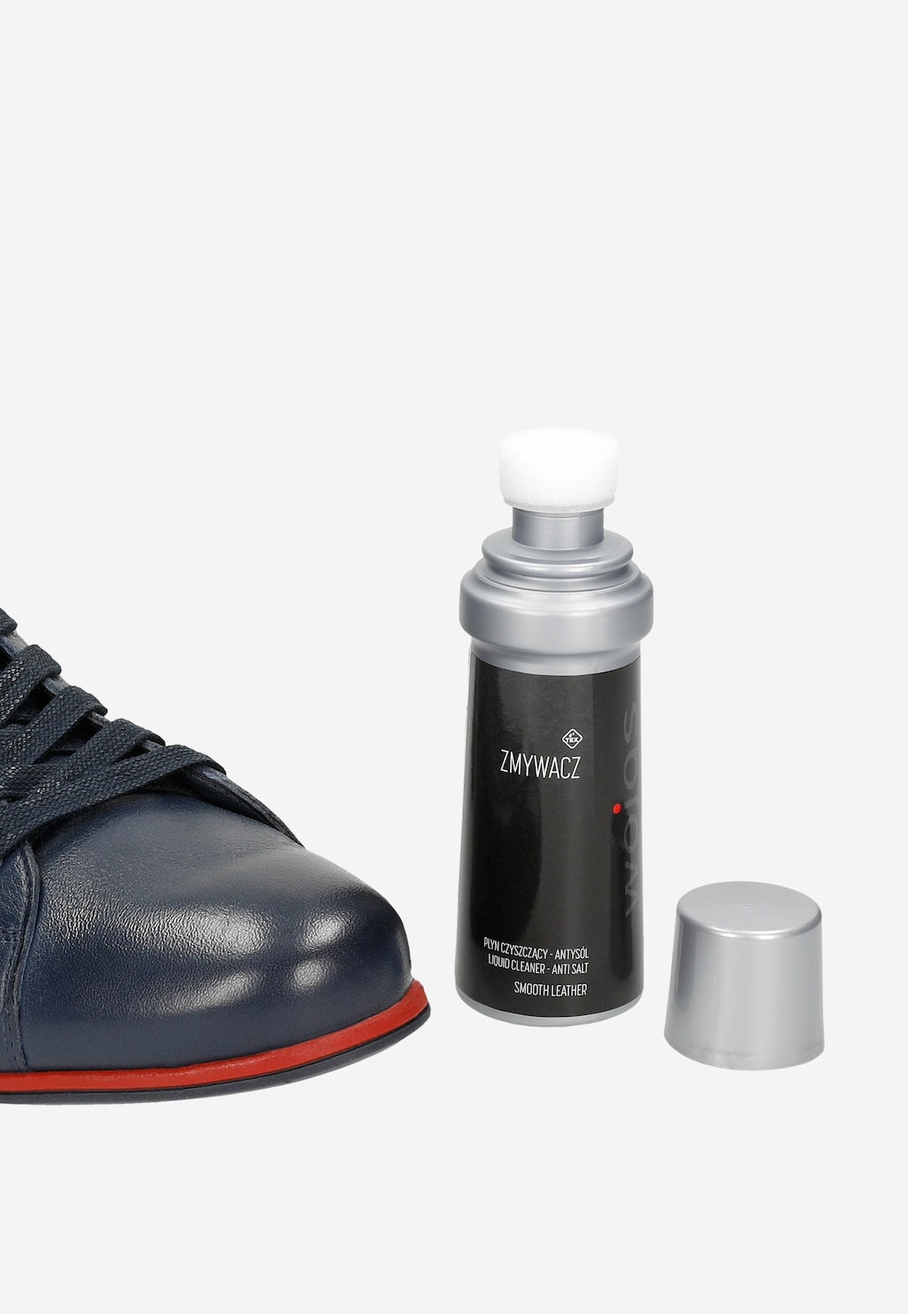 Zmywacz do obuwia Wojas 75 ml model 99011-00 w czarnej butelce ze srebrną nakrętką obok granatowego skórzanego buta z czerwoną podeszwą.