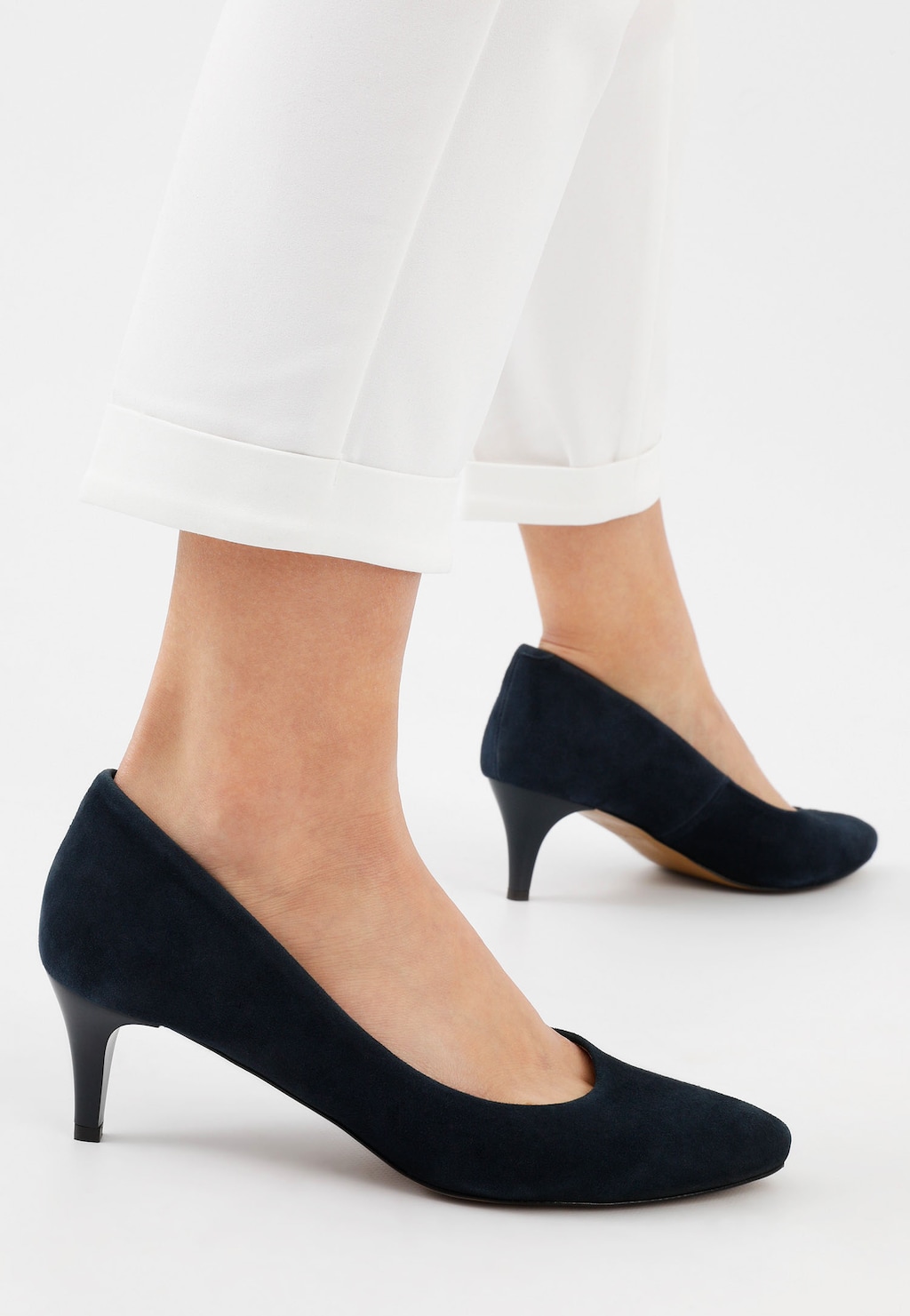 Granatowe czółenka Wojas model 35035-66 z niewysokimi obcasami, pokazane na nogach osoby w białych spodniach, widok z boku.