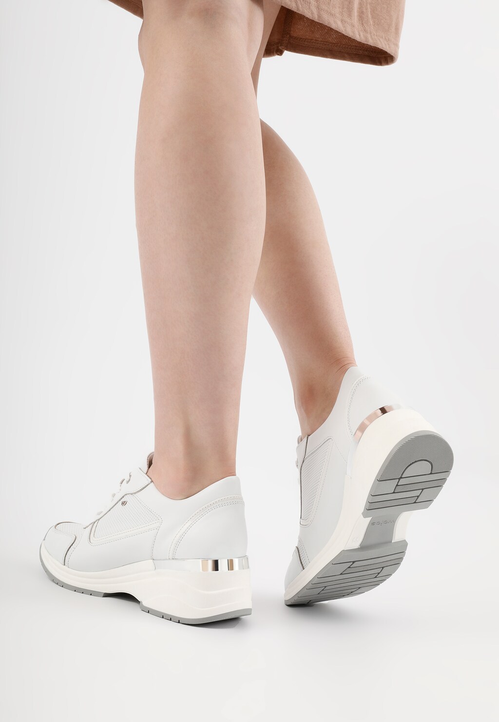 Białe sneakersy damskie Wojas 46115-79 na podwyższonej podeszwie, widok z tyłu ukazujący eleganckie wykończenie pięty z metalicznymi elementami i profilowaną podeszwę.