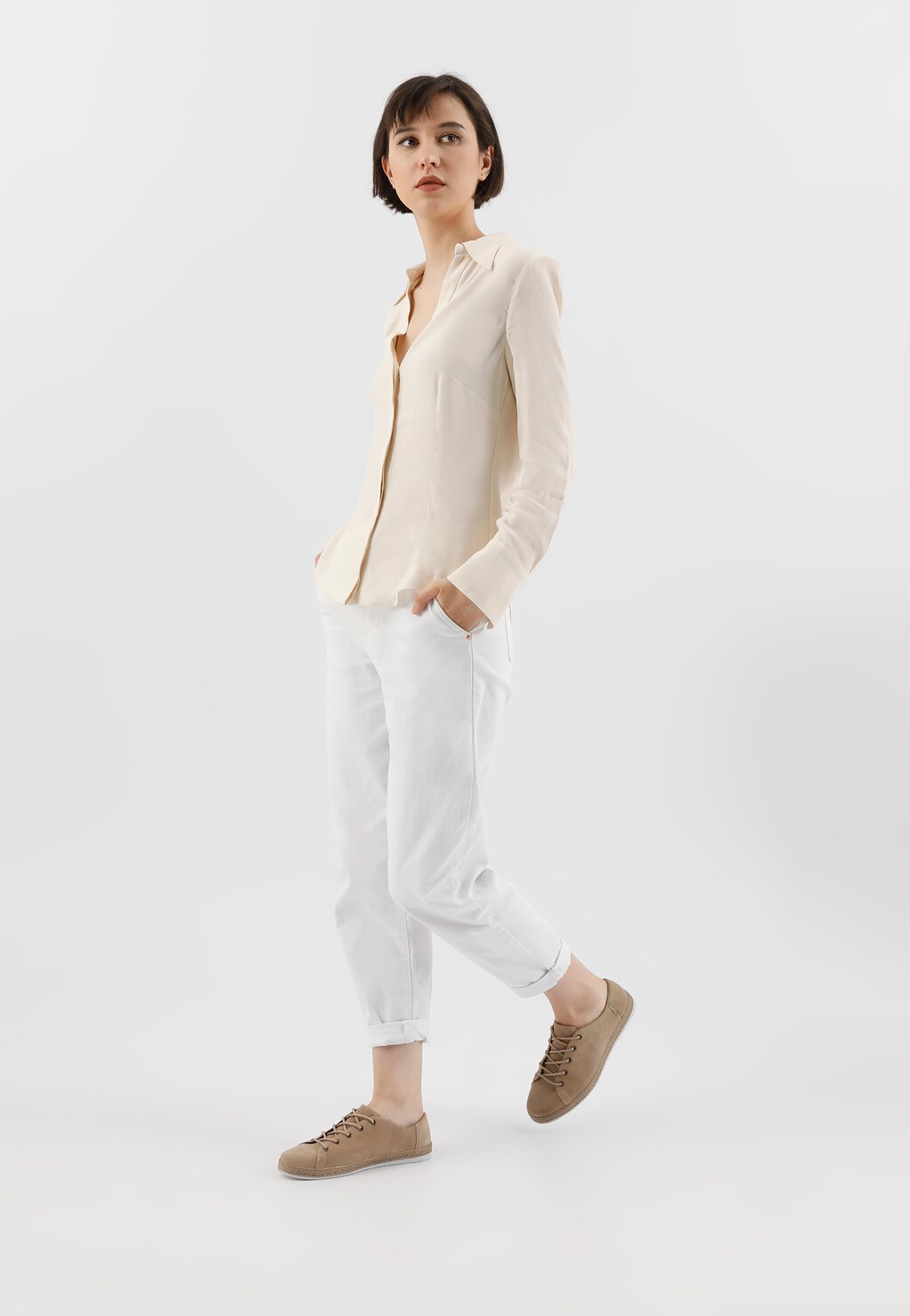 Elegancka kobieta w jasnym stroju prezentująca beżowe półbuty damskie Wojas model 46150-64 wykonane z dwoiny, doskonale uzupełniające casualowy outfit.