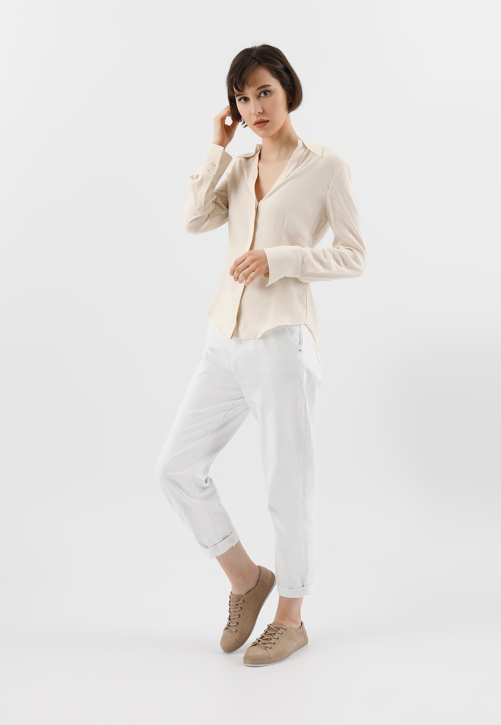 Beżowe półbuty damskie Wojas model 46150-64 prezentowane na modelce ubranej w białe spodnie i kremową koszulę, ukazujące casualowy, elegancki styl obuwia.