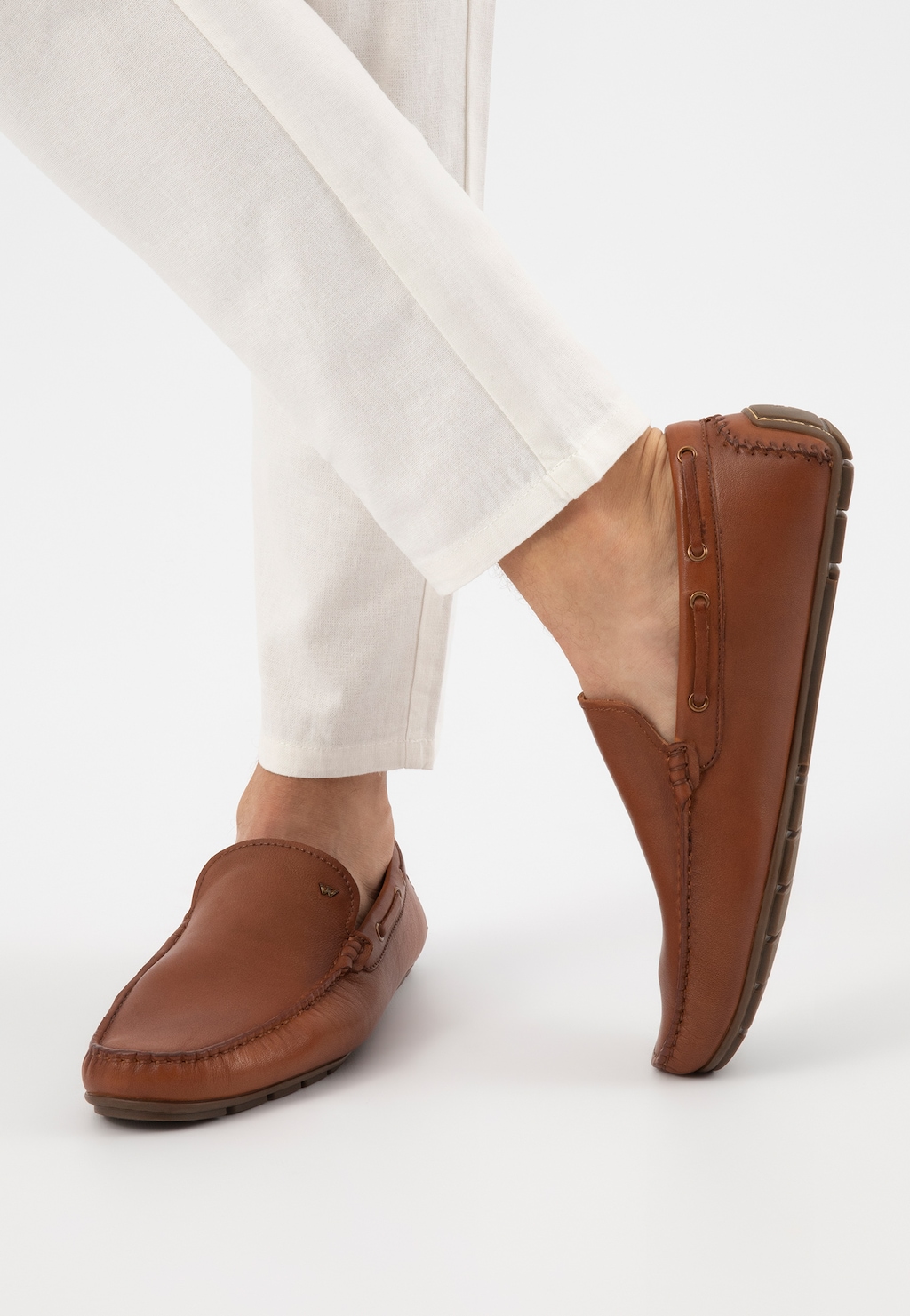 Jasnobrązowe skórzane mokasyny męskie Wojas 10047-52 prezentowane na nodze w białych spodniach, widok z boku pokazujący elegancki profil i wygodny krój obuwia.