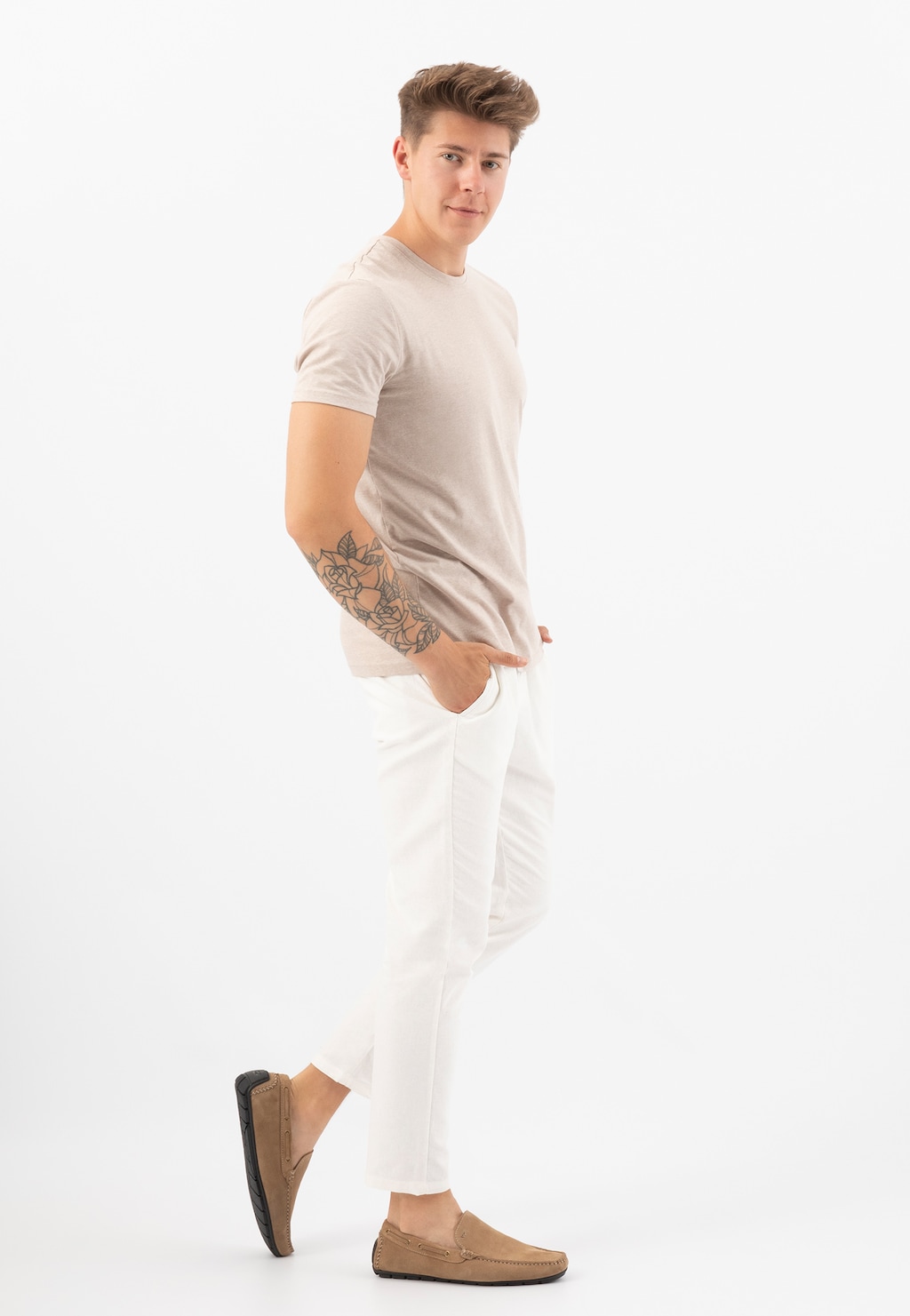 Beżowe mokasyny męskie Wojas 10047-64 z dwoiny welurowej pokazane na modelu w beżowej koszulce i białych spodniach, widok z boku eksponujący minimalistyczny design butów.