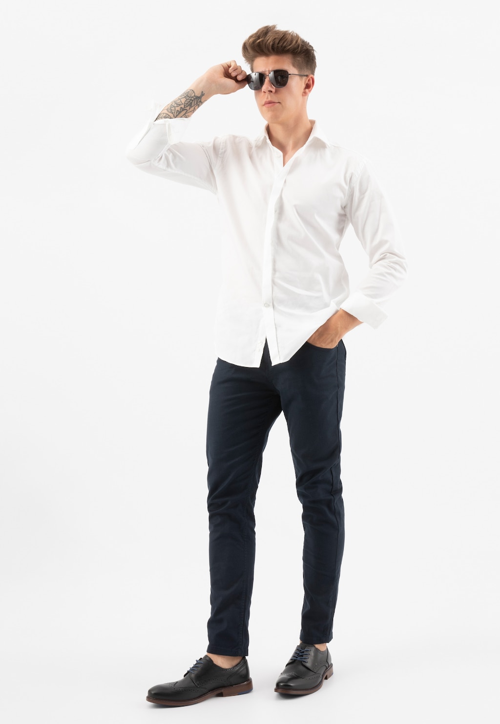 Mężczyzna w białej koszuli i granatowych spodniach, noszący okulary przeciwsłoneczne, prezentujący czarne półbuty męskie Wojas model 9072-51, widok pełnej sylwetki.