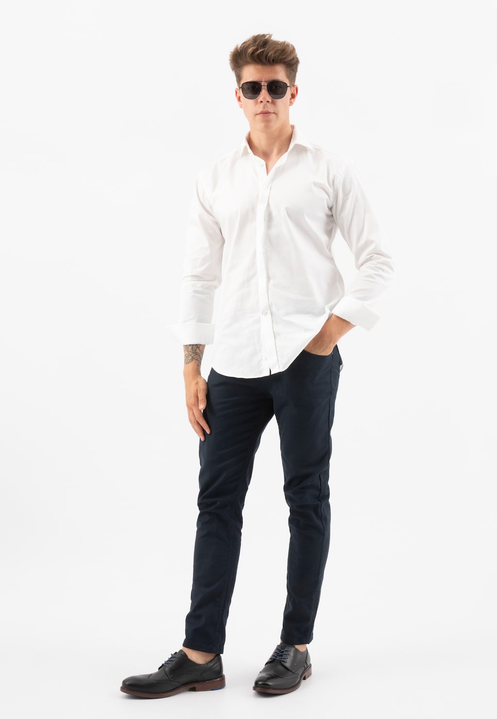 Elegancki mężczyzna w białej koszuli i granatowych spodniach prezentujący czarne półbuty męskie Wojas model 9072-51, idealne do formalnych stylizacji.