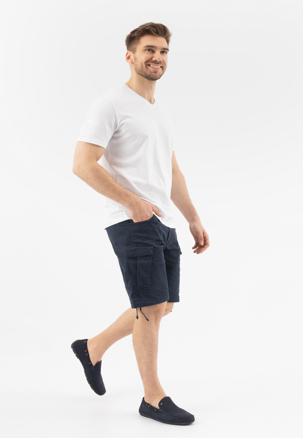 Mężczyzna w białej koszulce i granatowych szortach prezentujący granatowe mokasyny męskie Wojas 10103-26 z perforowaną skórą nubukową w casualowym stylu.