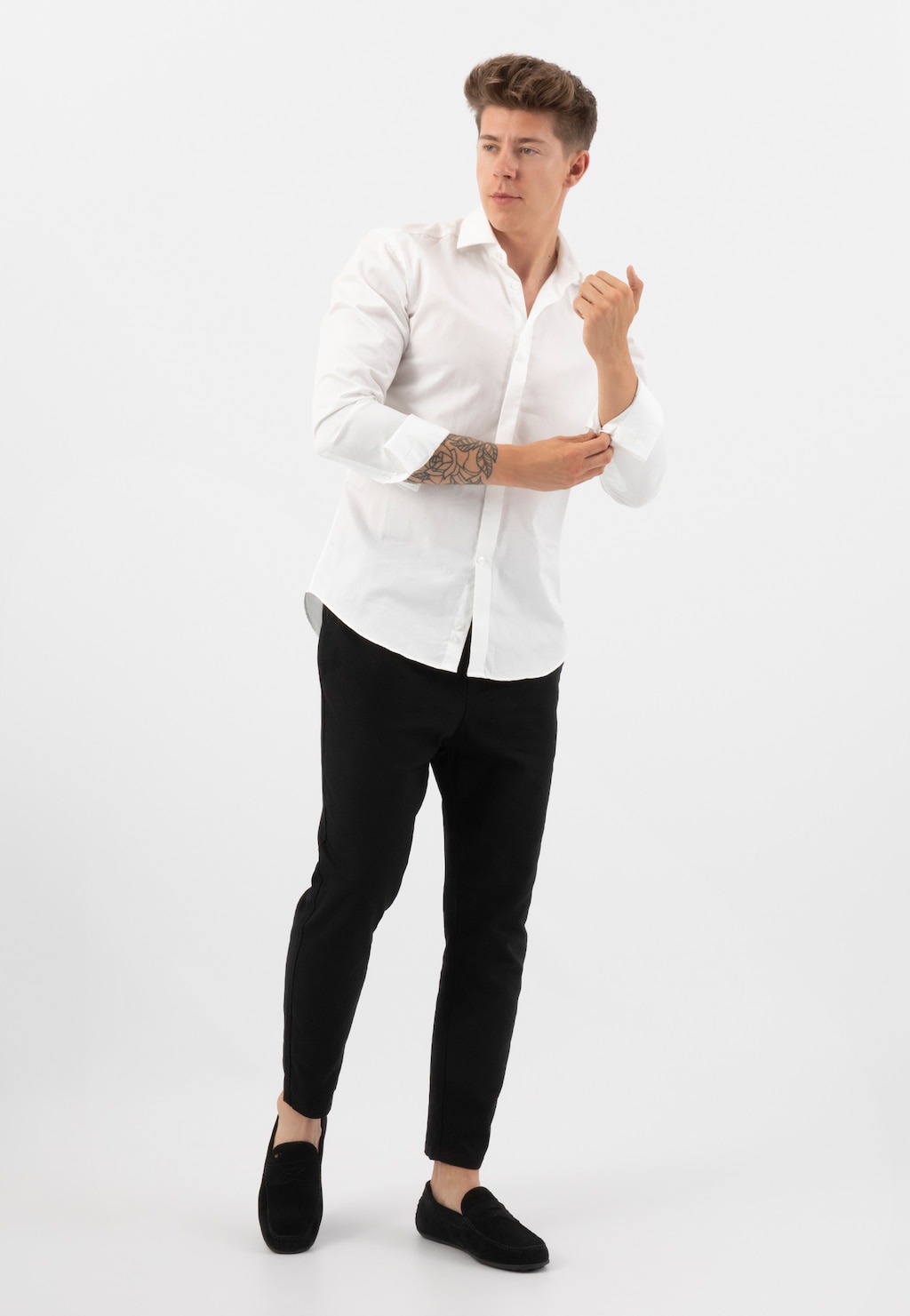 Mężczyzna w eleganckiej białej koszuli i czarnych spodniach prezentujący czarne mokasyny męskie Wojas model 10116-61 w stylu casual, idealne do codziennych stylizacji.