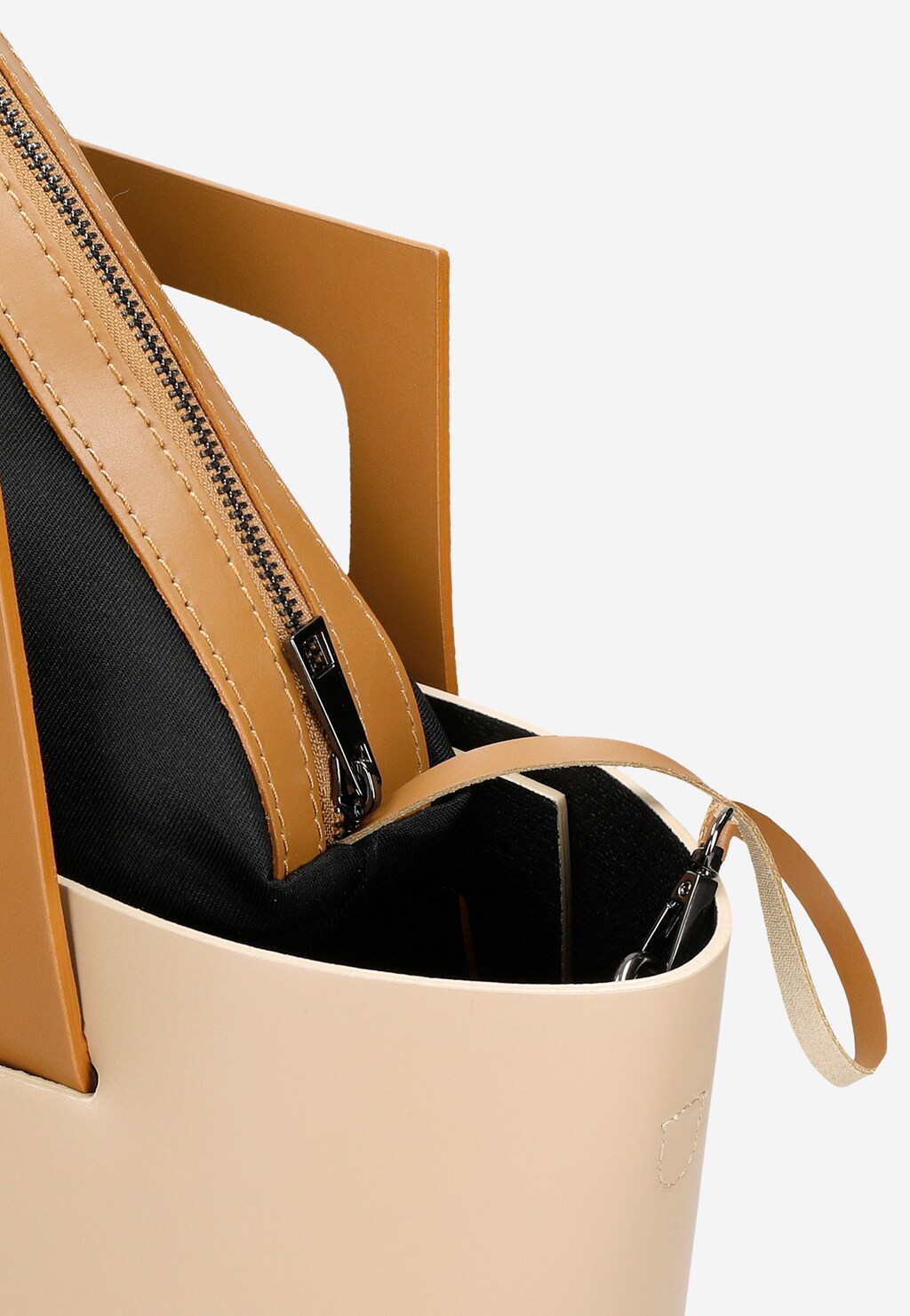 Elegancki beżowy kuferek Wojas 80322-54 z brązowymi elementami, wykonany ze skóry, z widocznym zamkiem błyskawicznym i czarnym wnętrzem, sfotografowany z góry.