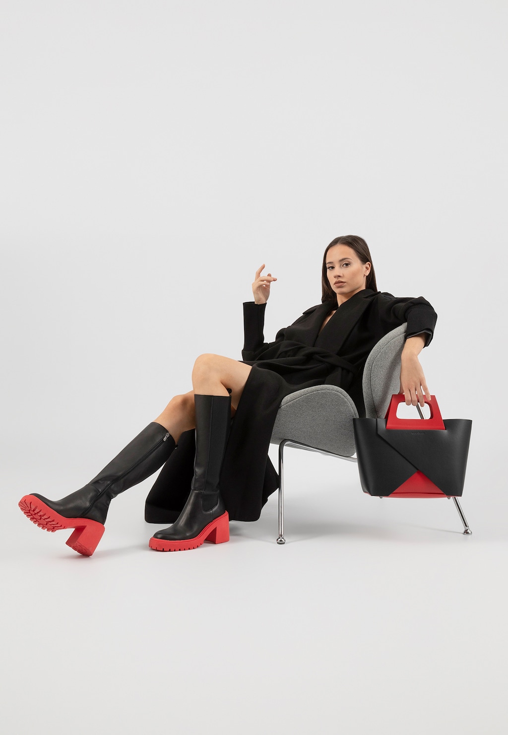 Eleganckie czarne kozaki sztyblety Wojas 71110-51 z charakterystyczną czerwoną podeszwą na obcasie, prezentowane z czarno-czerwoną torebką i czarną stylizacją.