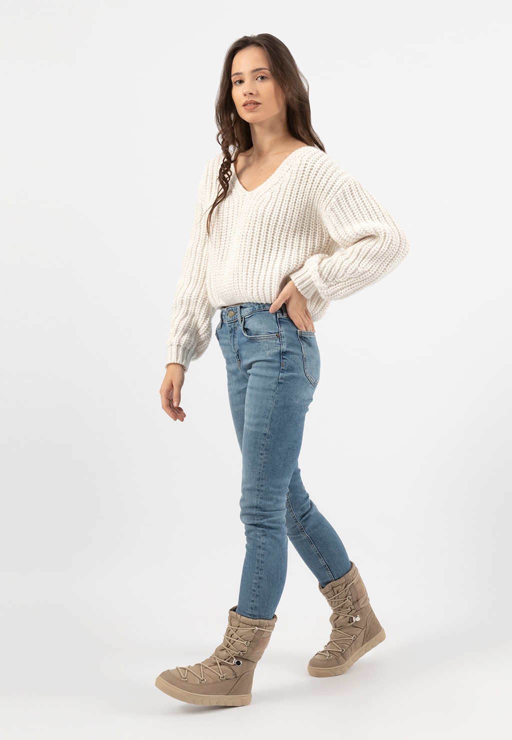 Kobieta w białym swetrze i jeansach prezentująca beżowe wysokie śniegowce damskie RELAKS model R55121-84, ukazane z boku w pełnej długości.