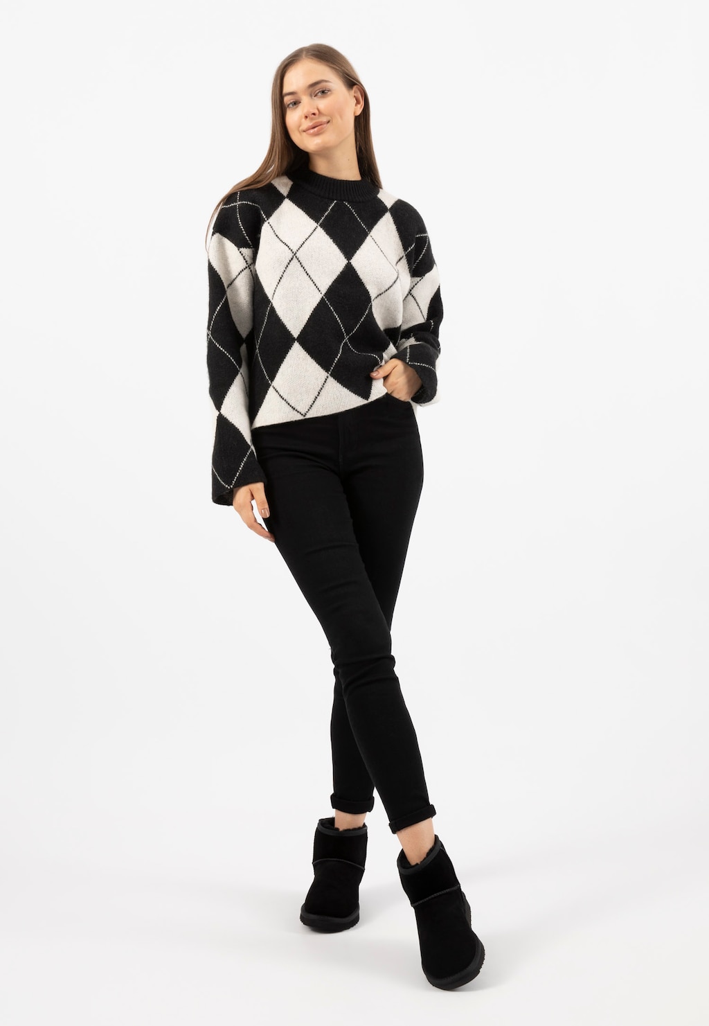 Kobieta w czarno-białym swetrze w romby i czarnych spodniach, prezentująca ciepłe czarne śniegowce damskie RELAKS model R55003-61.