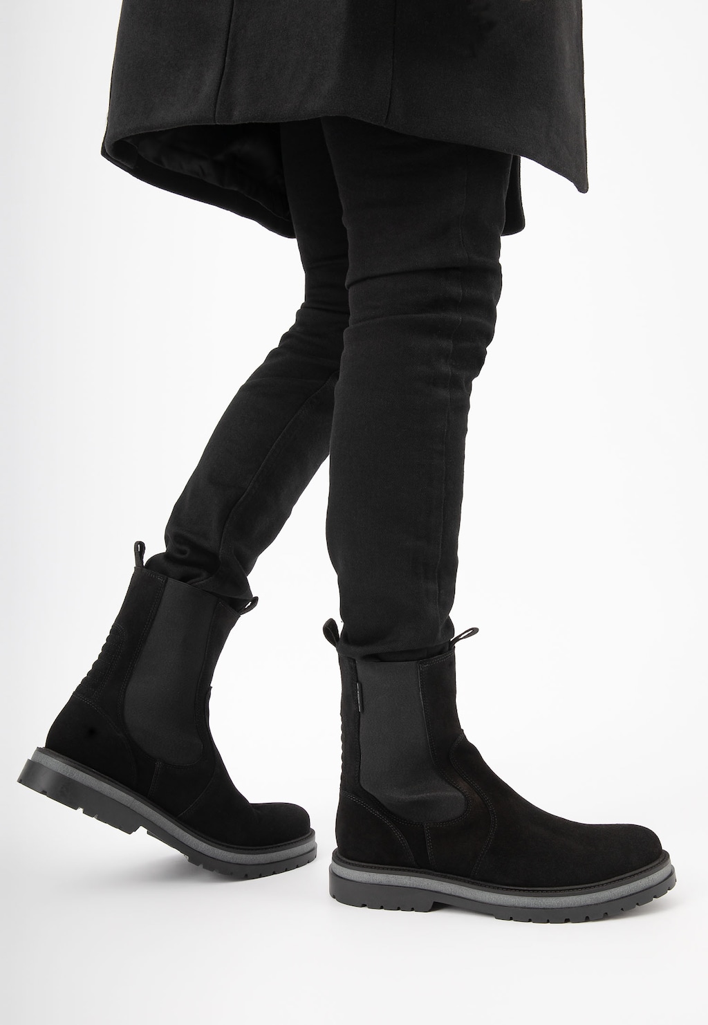 Eleganckie czarne sztyblety męskie Wojas 20021-61 z wysoką cholewką, prezentowane na modelu w ciemnych spodniach, widok z boku pokazujący klasyczny design obuwia.