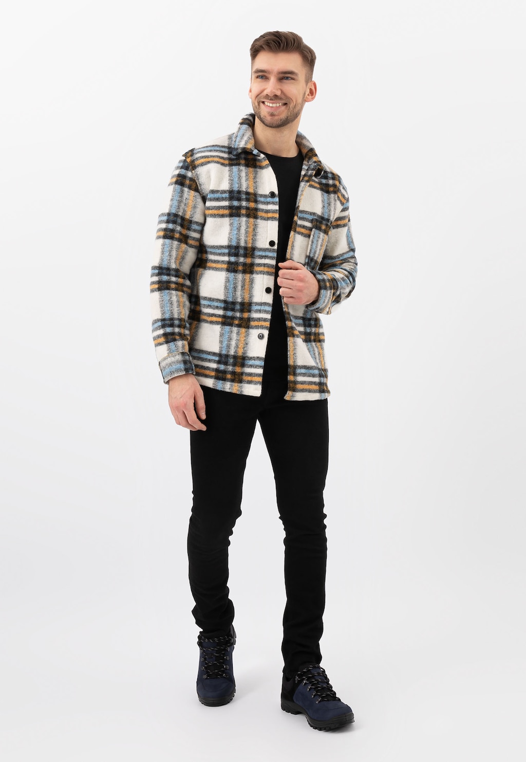 Mężczyzna w kraciastej koszuli i czarnych spodniach prezentuje czarno-granatowe półbuty trekkingowe Wojas model 10068-96, pokazane w pełnej stylizacji.