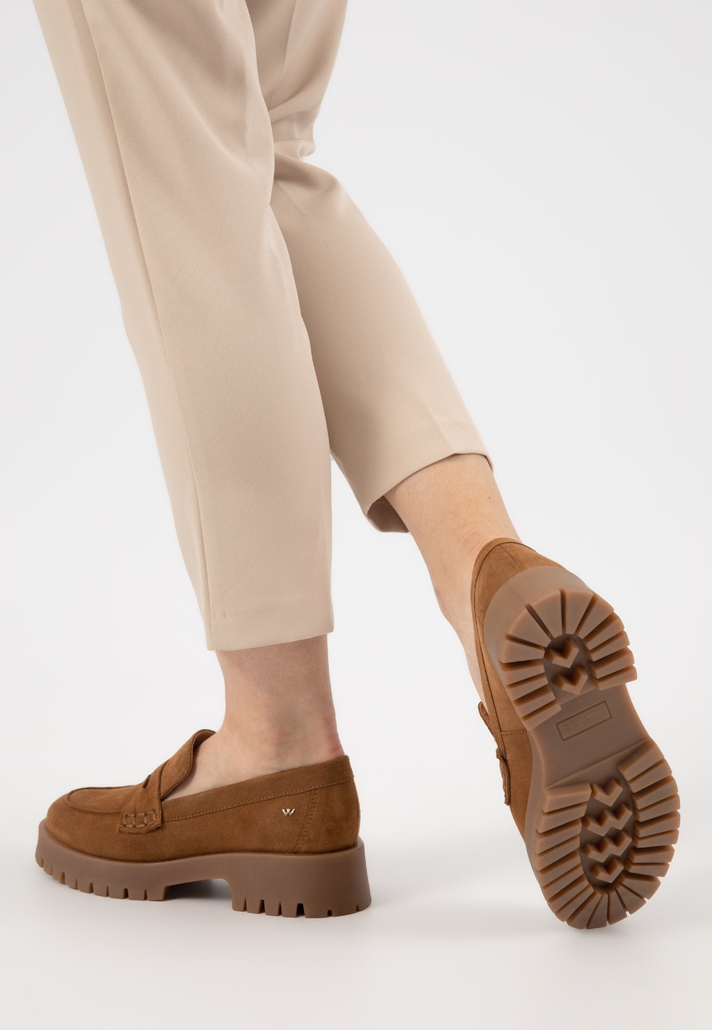 Jasnobrązowe damskie mokasyny Wojas 46124-63 z dwoiny welurowej na grubej podeszwie, pokazane z boku i od spodu, noszone do beżowych spodni.