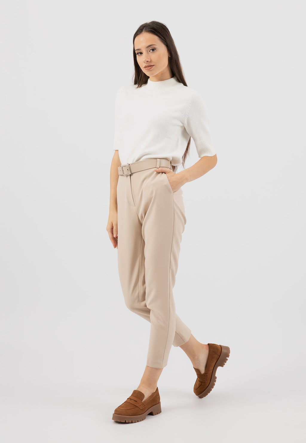 Modelka w białej bluzce i beżowych spodniach prezentuje jasnobrązowe mokasyny Wojas z dwoiny welurowej model 46124-63 na grubej podeszwie.