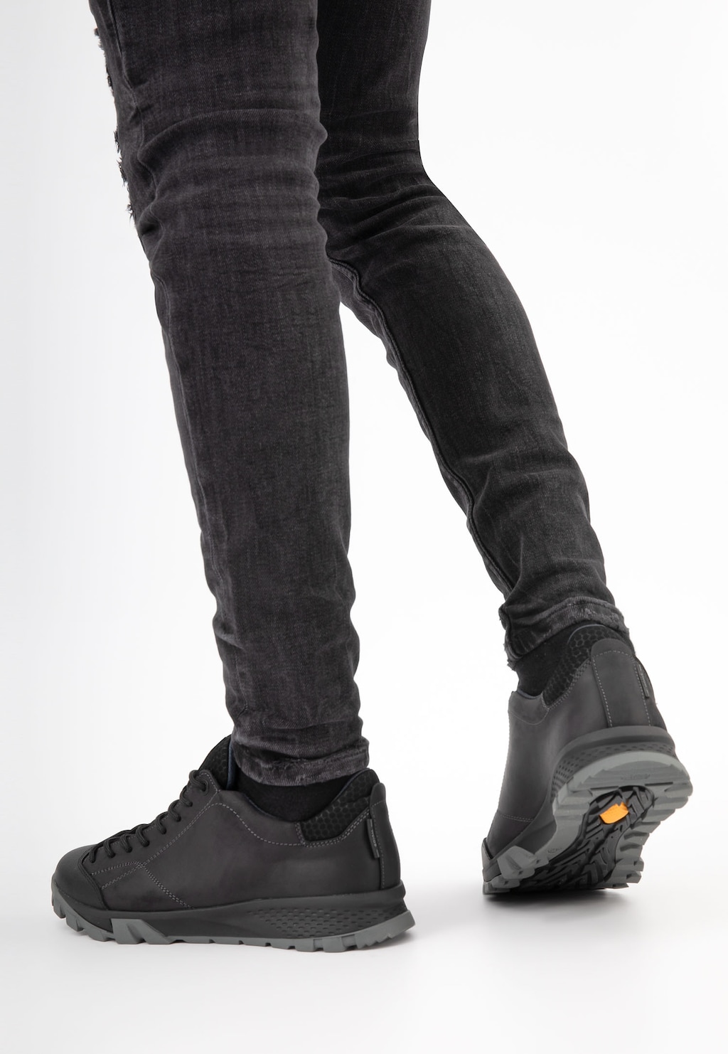 Czarne półbuty trekkingowe Wojas 10139-71 na nogach osoby w ciemnych jeansach, widok z boku pokazujący profilowaną podeszwę i sportowy charakter obuwia.