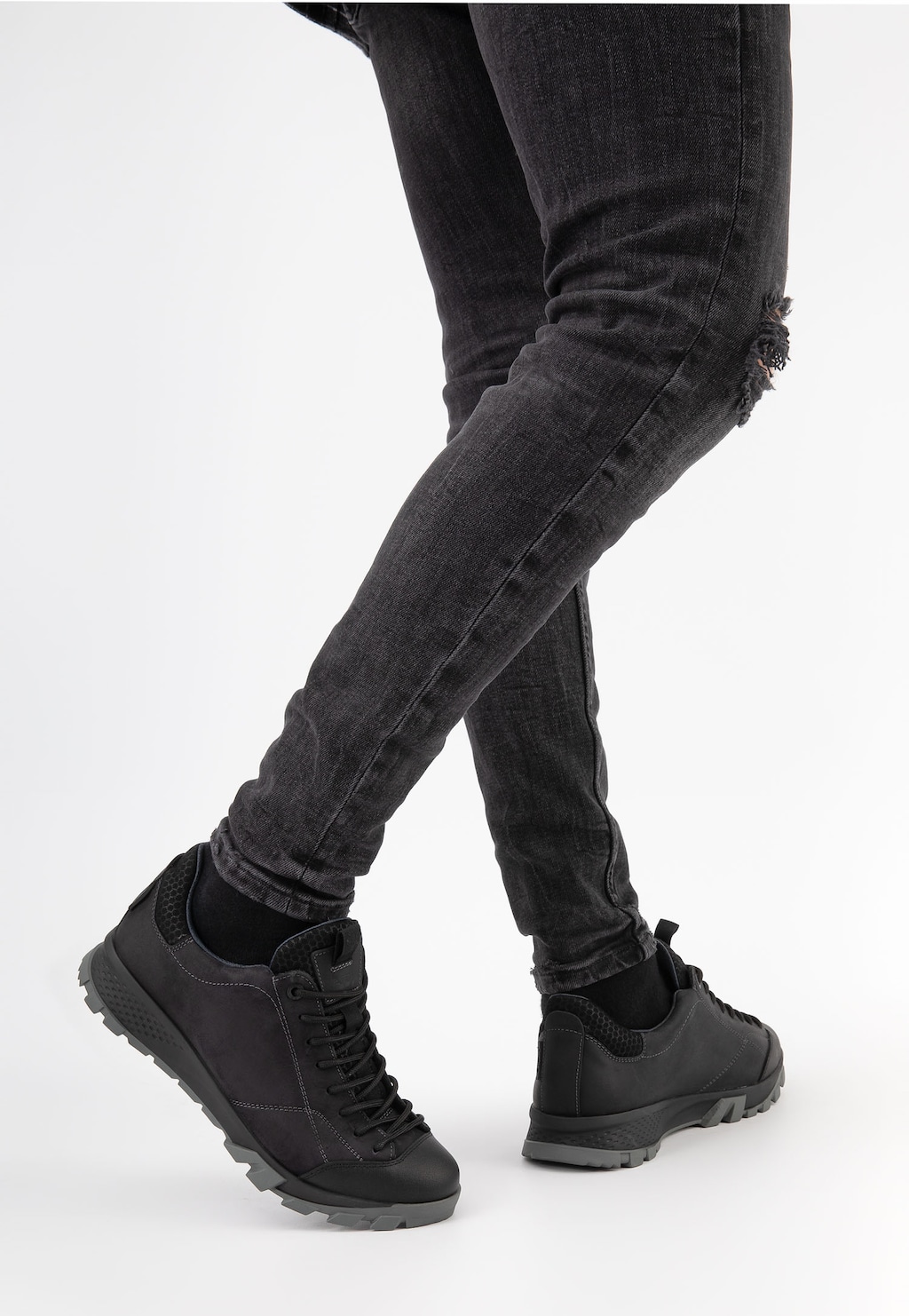Czarne półbuty trekkingowe Wojas model 10139-71 noszone przez osobę w ciemnych jeansach, widoczne z boku, podkreślające sportowy charakter i wytrzymałą podeszwę.