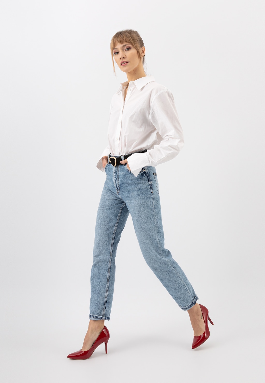 Eleganckie czerwone czółenka Wojas model 9275-35 z lakierowanej skóry prezentowane na modelce w białej koszuli i jasnoniebieskich jeansach.