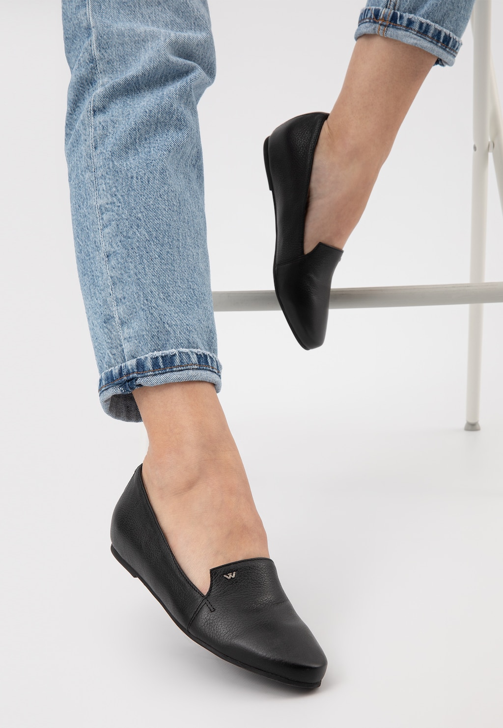 Czarne lordsy damskie Wojas model 45003-50 na płaskiej podeszwie, prezentowane na nogach w jasnoniebieskich jeansach, widok z boku pokazujący elegancki profil obuwia.