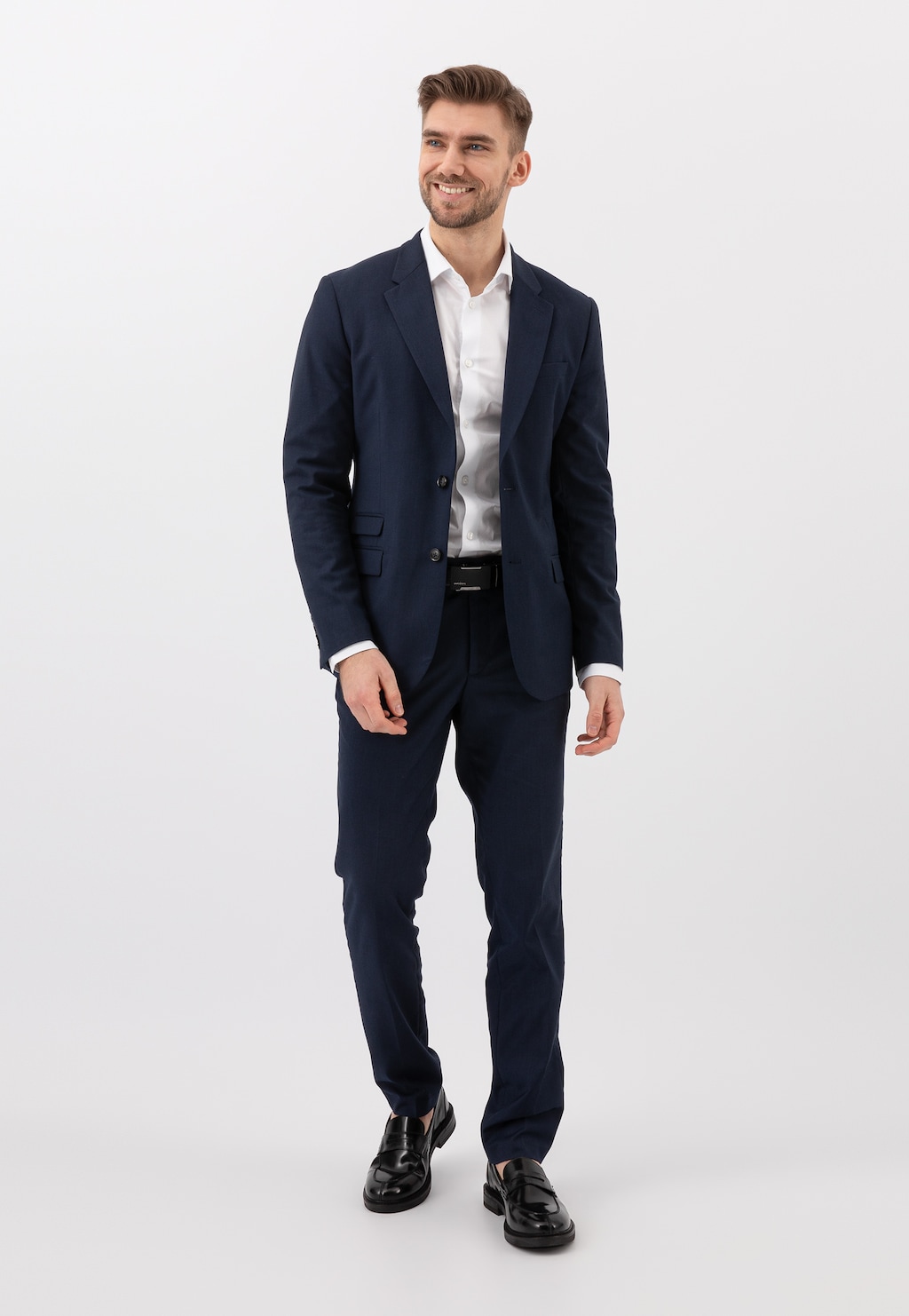 Elegancki mężczyzna w granatowym garniturze i białej koszuli prezentuje czarne lakierowane mokasyny męskie Wojas model 10137-31 typu penny loafers.