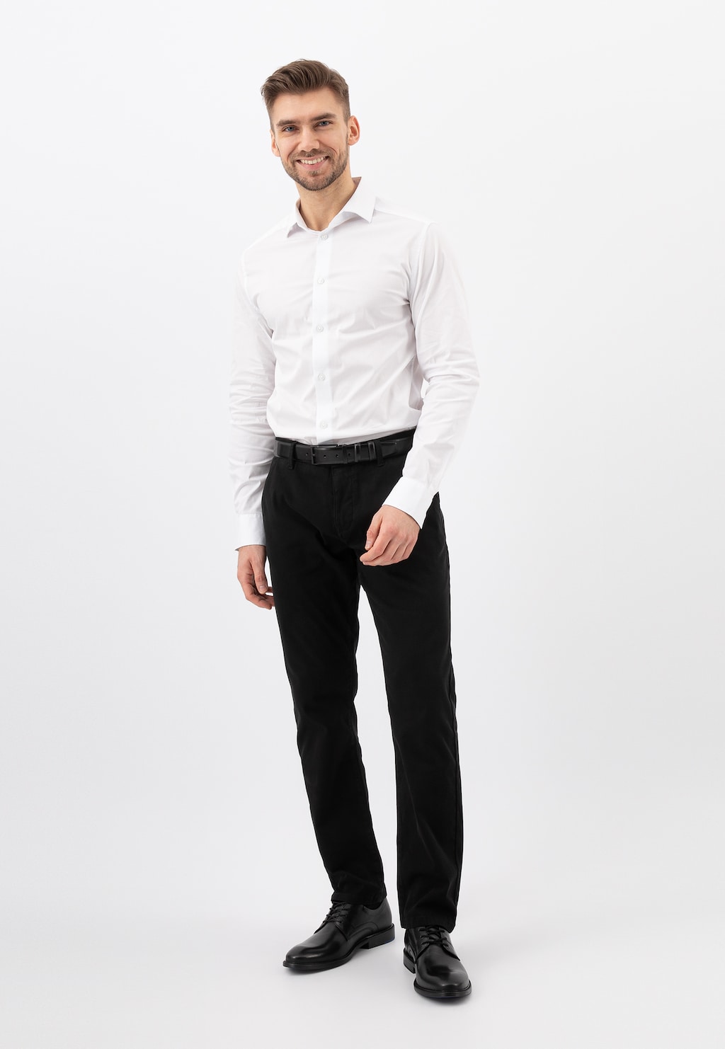 Mężczyzna w eleganckim stroju biznesowym: biała koszula i czarne spodnie, prezentujący eleganckie półbuty męskie Wojas model 10133-51, idealne do formalnych stylizacji.