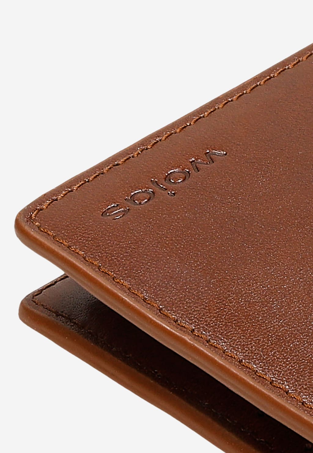 Duży skórzany portfel męski Wojas 91072-53 w jasnobrązowym kolorze z wytłoczonym logo marki na powierzchni licowej, ukazany w zbliżeniu.