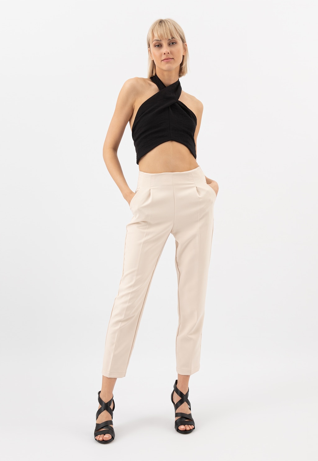 Elegancki strój z czarnym topem typu halter i kremowymi spodniami, uzupełniony czarnymi sandałami Wojas na szpilce model 76045-51 - idealne do stylizacji wieczorowych.