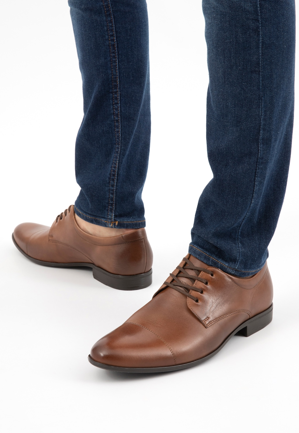 Brązowe eleganckie półbuty męskie Wojas model 9036-52 noszone z granatowymi jeansami, widok z perspektywy stóp, ukazujący skórzane wykończenie i sznurowany fason.