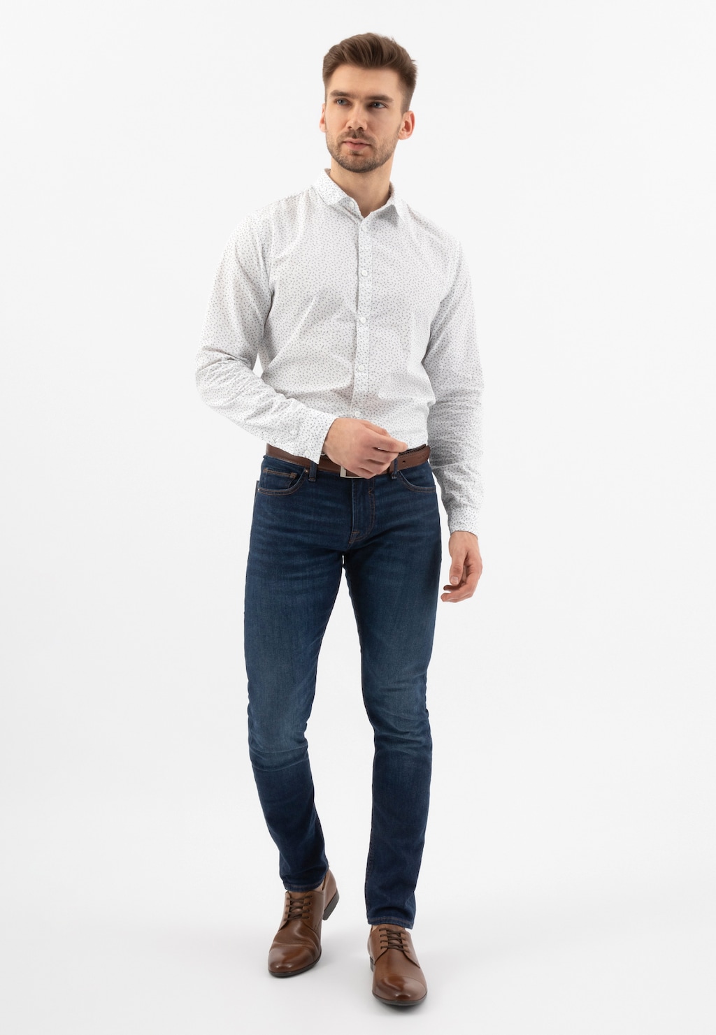 Model w eleganckim stroju prezentujący brązowe półbuty męskie Wojas model 9036-52, idealne uzupełnienie stylizacji z białą koszulą i granatowymi jeansami.