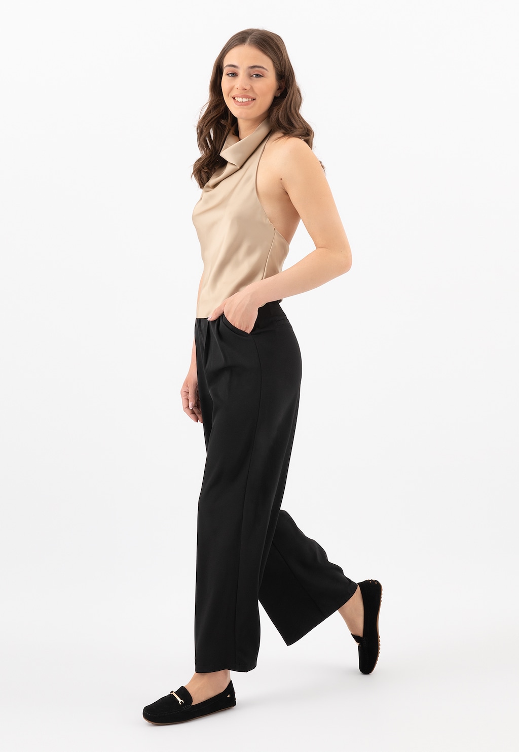 Modelka w eleganckim stroju z czarnymi mokasynami Wojas model 46210-61 typu car shoes, idealnymi do stylizacji biznesowej i casualowej.