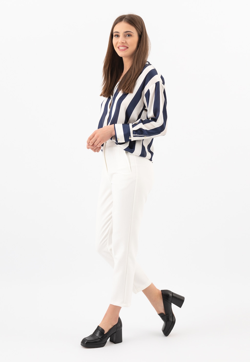 Modelka w biało-granatowej koszuli w paski i białych spodniach, prezentująca czarne wysokie skórzane mokasyny damskie Wojas 46219-51 z kwadratowym noskiem na grubym obcasie.