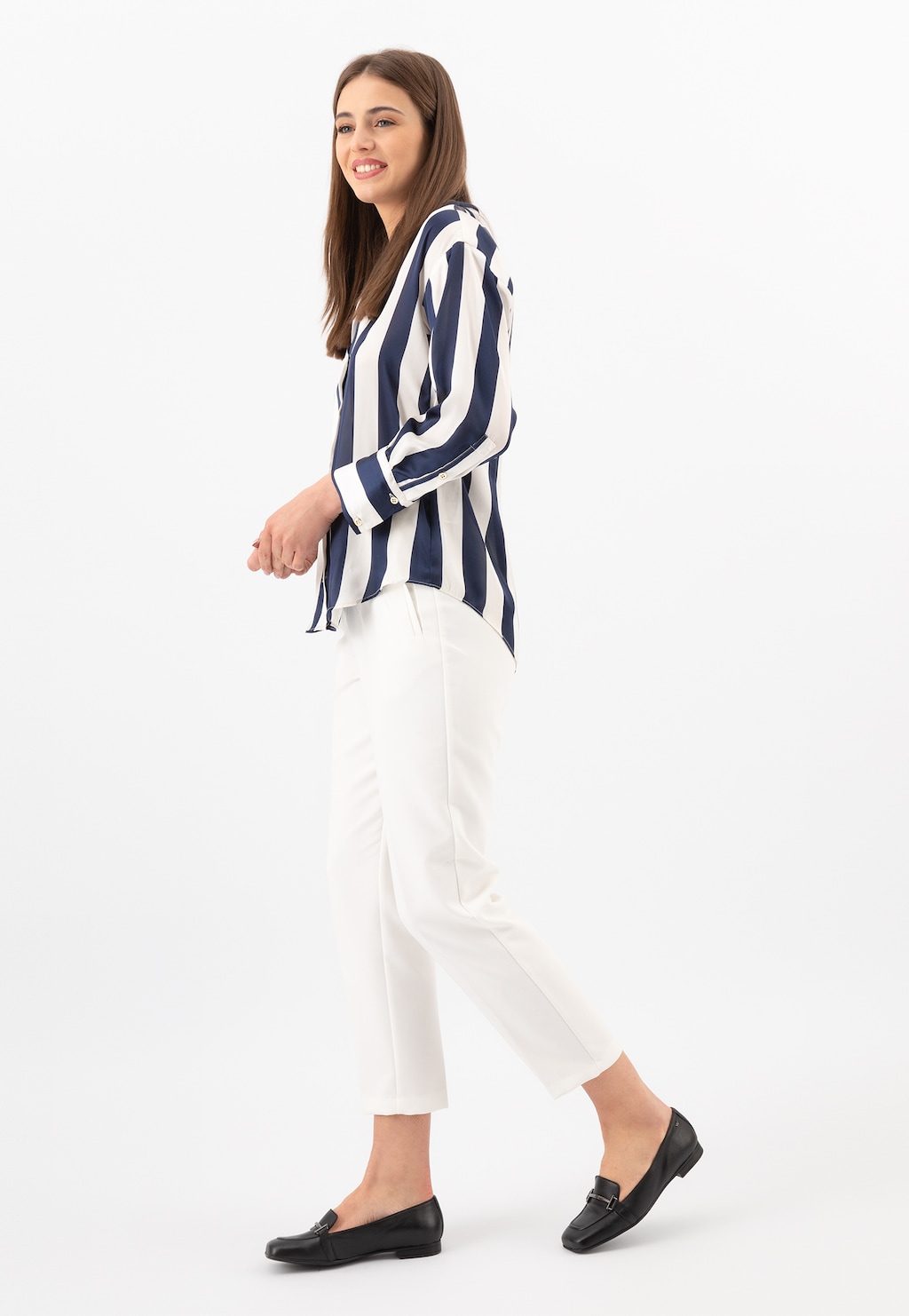 Stylizacja z czarnymi mokasynami damskimi Wojas model 46226-51 z metalową ozdobą, w połączeniu z białymi spodniami i biało-granatową koszulą w paski.