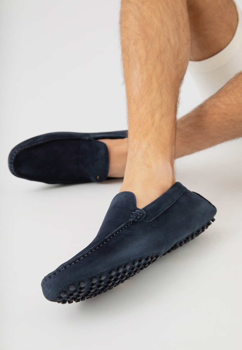 Granatowe skórzane mokasyny męskie Wojas model 10145-66 typu car shoes z charakterystyczną gumową podeszwą z wypustkami, prezentowane na stopach mężczyzny.