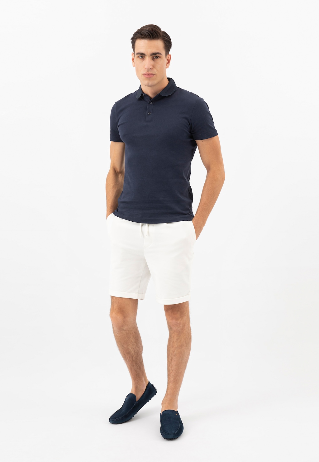 Model prezentujący granatowe skórzane mokasyny męskie Wojas 10145-66 typu car shoes, ubrany w granatową koszulkę polo i białe szorty.