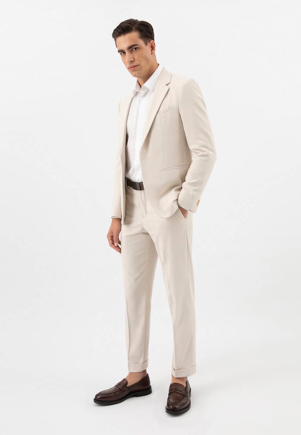 Elegancki mężczyzna w kremowym garniturze, białej koszuli i brązowych mokasynach męskich Wojas ze skóry licowej model 10137-52, prezentujących stylowe uzupełnienie formalnej stylizacji.