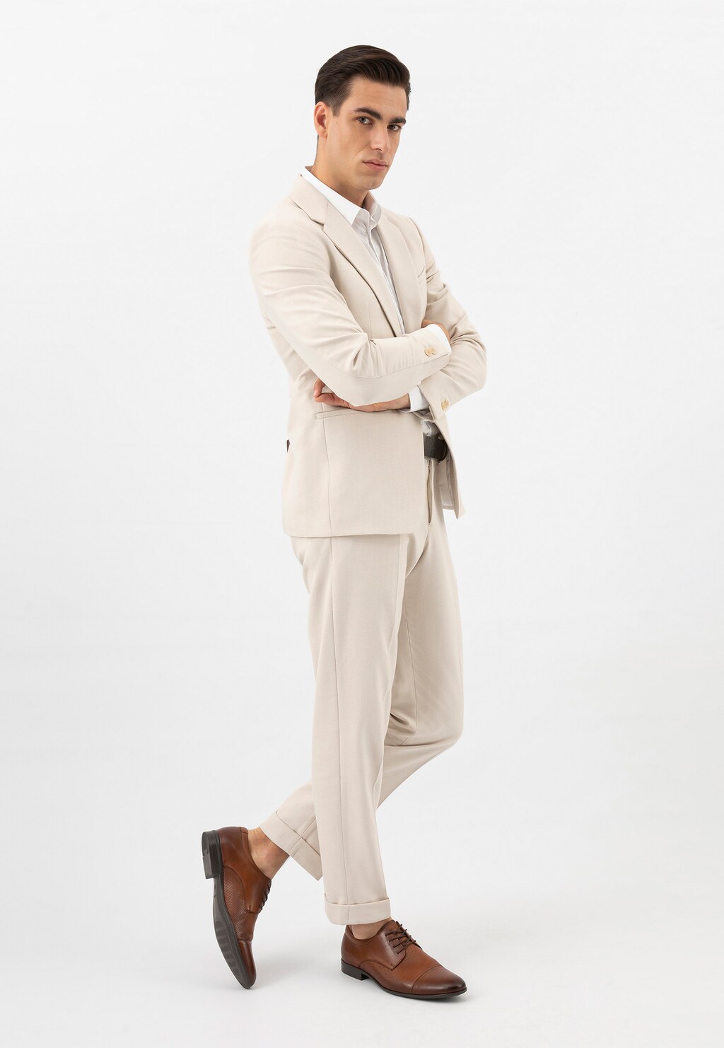 Model w jasnym garniturze prezentuje eleganckie brązowe półbuty męskie Wojas model 10140-52, idealnie dopasowane do biznesowej stylizacji.