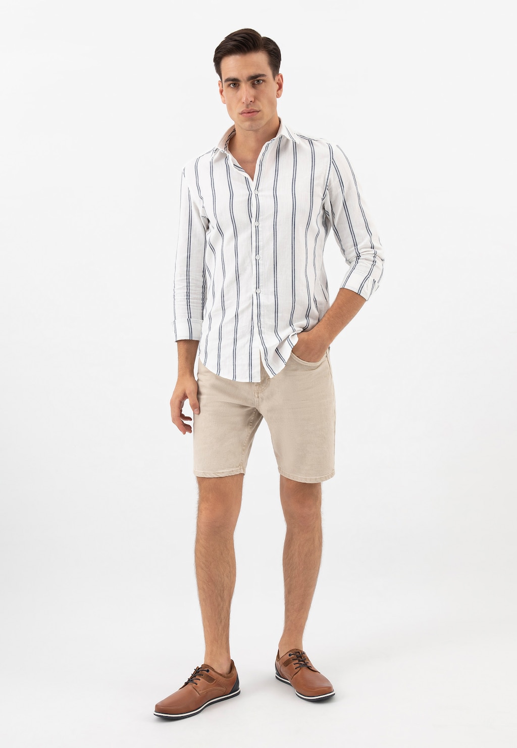 Eleganckie półbuty męskie Wojas model 10027-73 w brązowym kolorze z granatową wstawką, prezentowane na modelu ubranym w białą koszulę w paski i beżowe szorty.