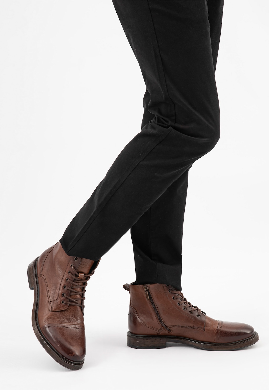 Klasyczne brązowe trzewiki męskie Wojas model 24035-52 na nogach mężczyzny w czarnych spodniach, widoczne z boku, z charakterystycznym sznurowaniem i zamkiem bocznym.