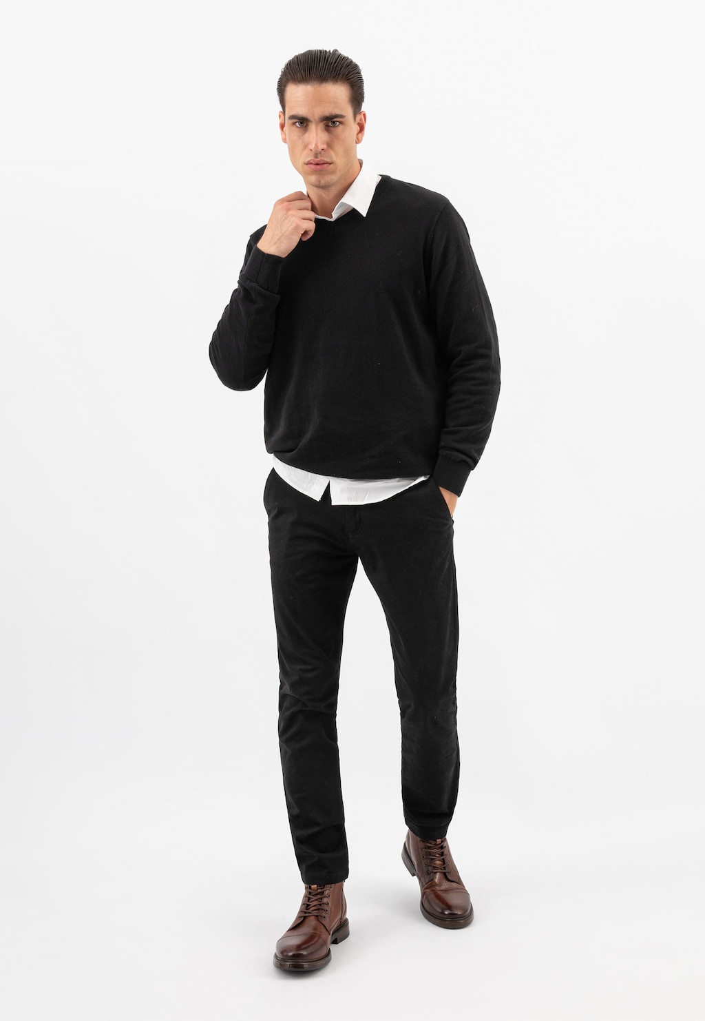 Model w eleganckim czarnym stroju prezentuje klasyczne brązowe trzewiki męskie Wojas model 24035-52, idealne do eleganckiej stylizacji biznesowej.