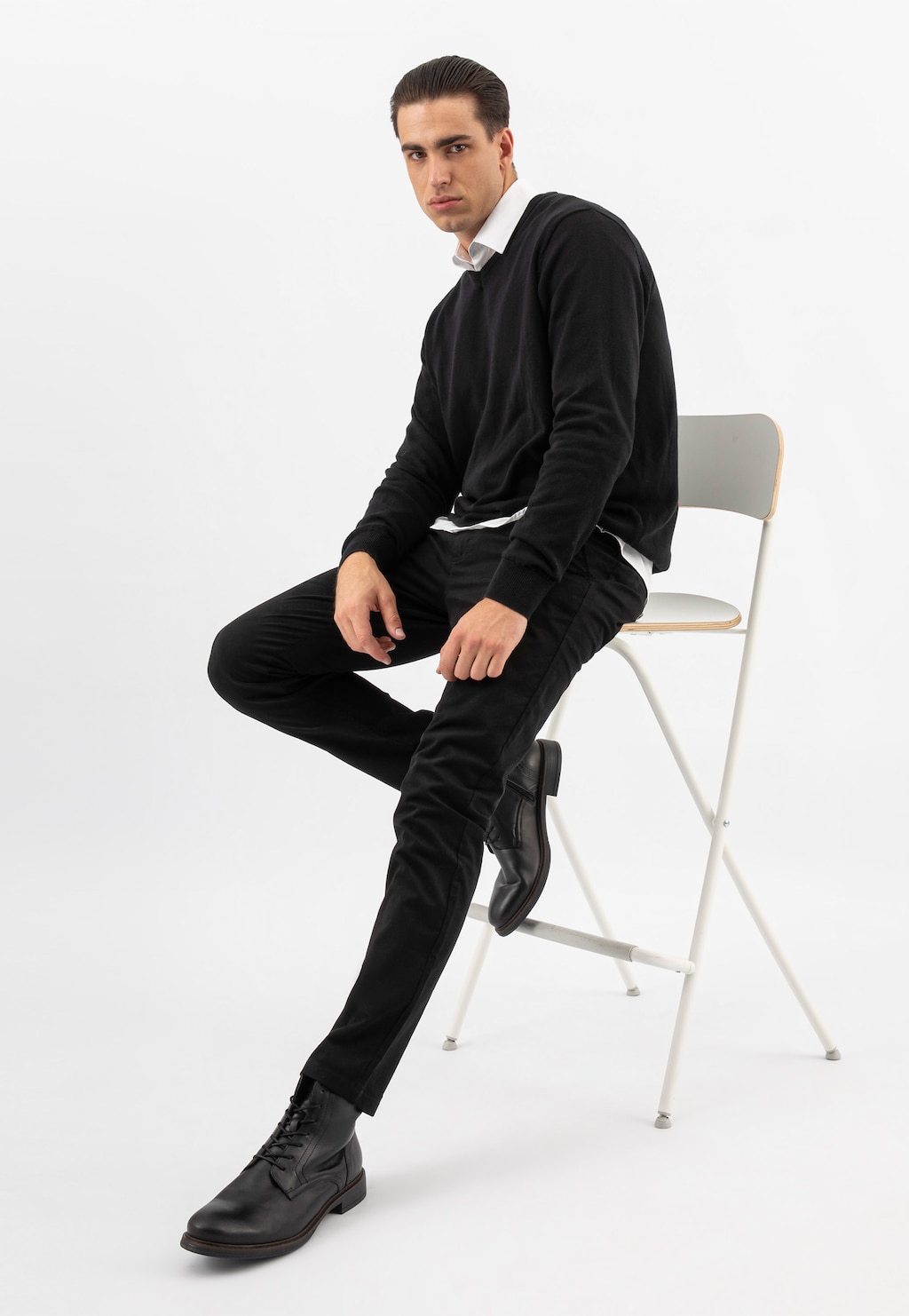 Model w eleganckim czarnym stroju prezentujący trzewiki męskie Wojas 24052-51 ze skóry licowej. Buty widoczne na nodze w stylizacji biznesowej.