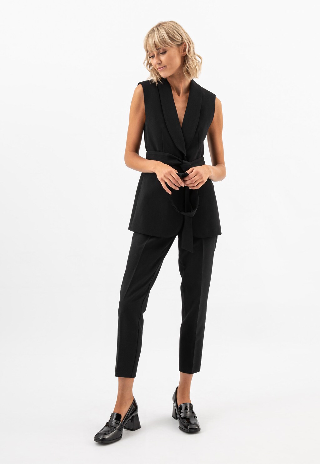 Elegancki czarny strój biznesowy z kamizelką i spodniami, uzupełniony czarnymi lakierowanymi mokasynami Wojas model 46204-31 na solidnym obcasie.